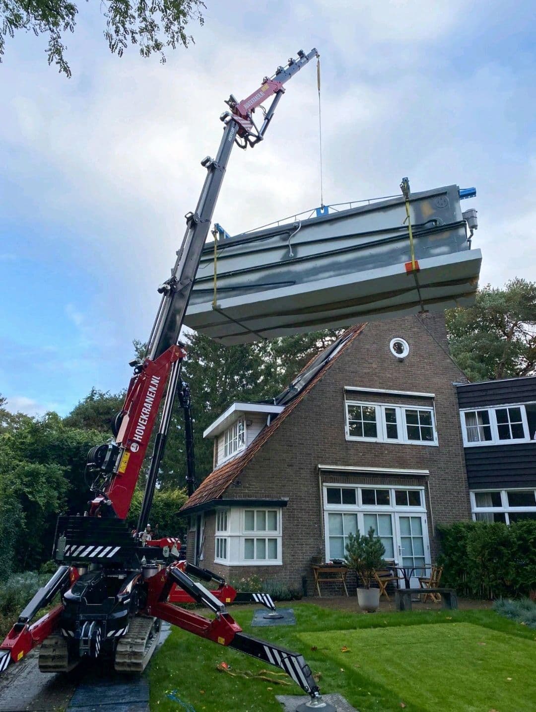 Hoeflon mini crane lifting a heavy object at a house.